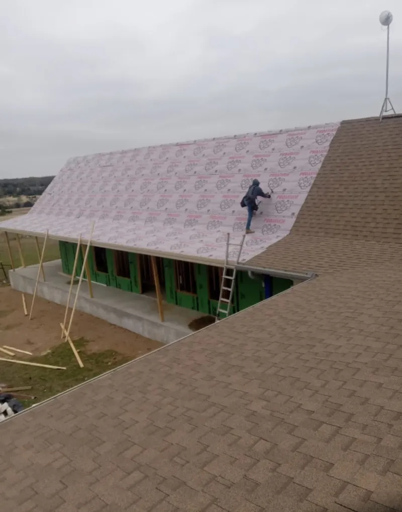 Worker preparing underlayment for a metal roof installation in Nebraska City